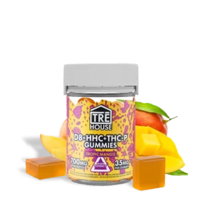 TRĒ House Tropic Mango gummies by THCGummies.com. Featured photo of the bottle and the gummies with a full size mango and sliced mango chunks in the background.